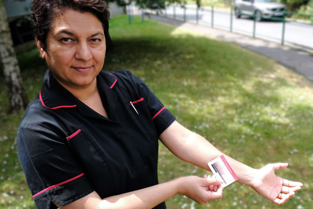 Luxmi Dhoonmoon with a skin tone card used in the process 