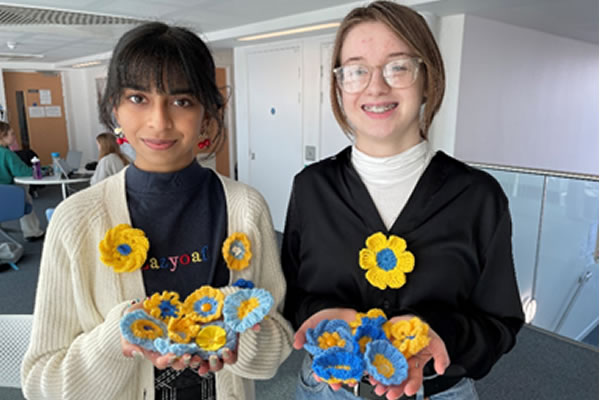 Students Sia Patel and Korina Szyszko-Nicewicz with a selection of their knitted flowers