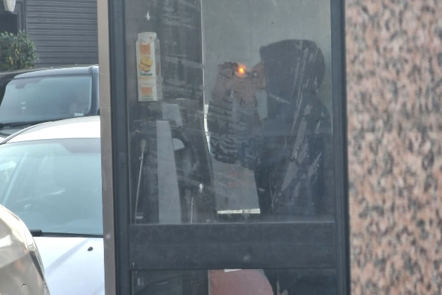 Person taking drugs in a BT phone box in Hanwell